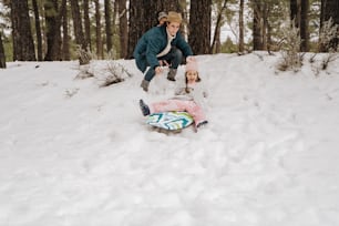 una donna e un bambino che giocano nella neve