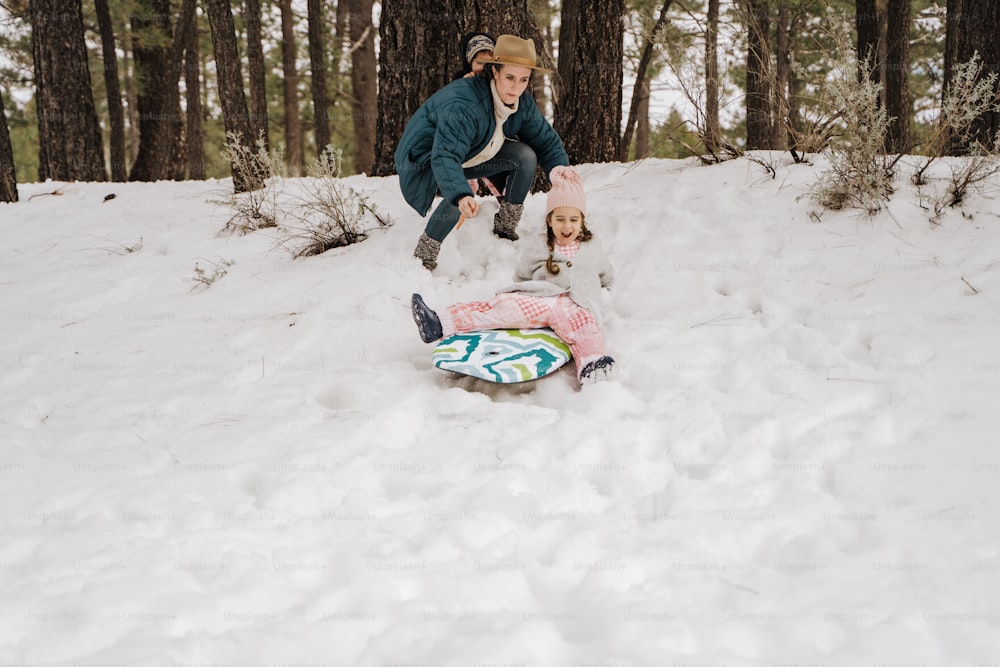 a woman and a child playing in the snow