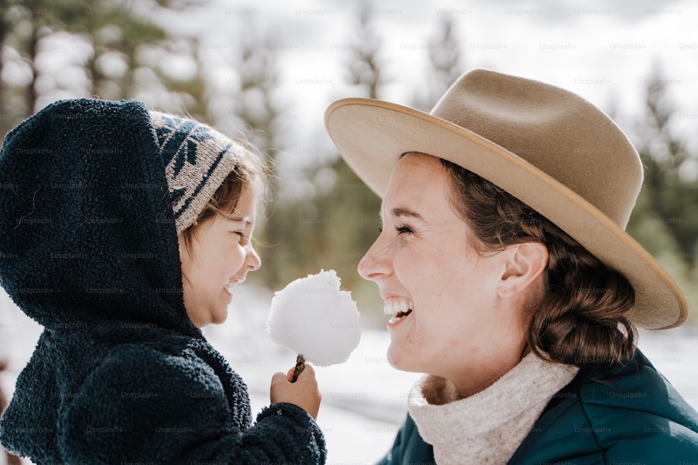 una mujer sosteniendo una bola de nieve y una niña
