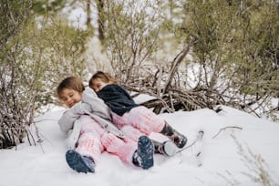 due bambine che si siedono insieme nella neve