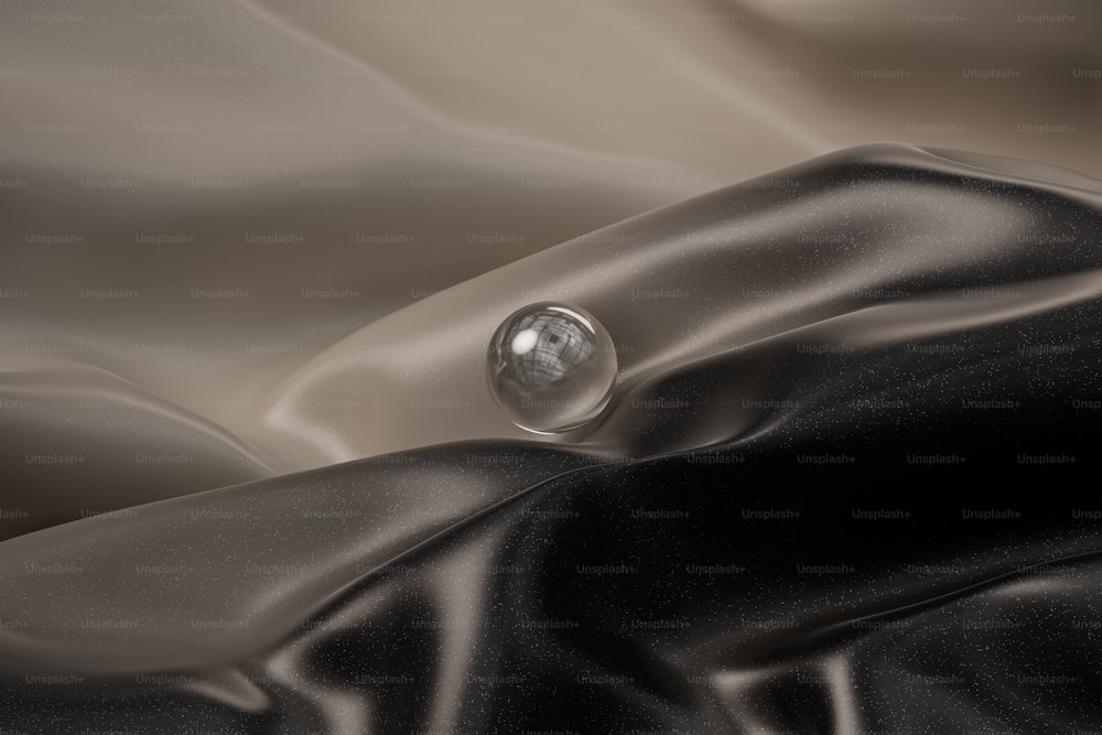 a drop of water sitting on top of a black cloth