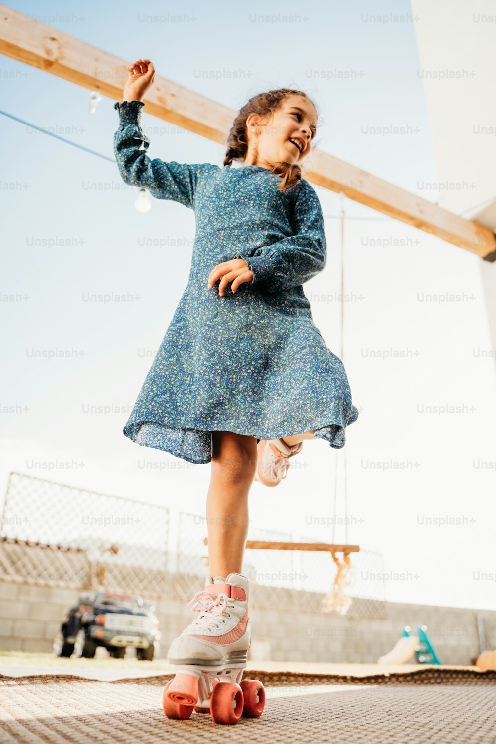 a little girl standing on top of a skateboard