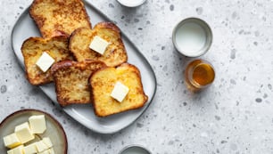 a plate of toasted bread with butter on top