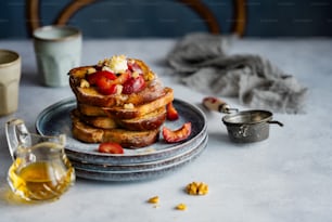 a stack of french toast with strawberries on top