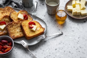 a plate of french toast with fruit and cheese