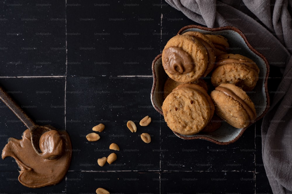 a bowl of peanut butter cookies next to a spoon