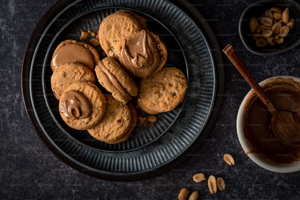 a plate of cookies and a bowl of peanut butter