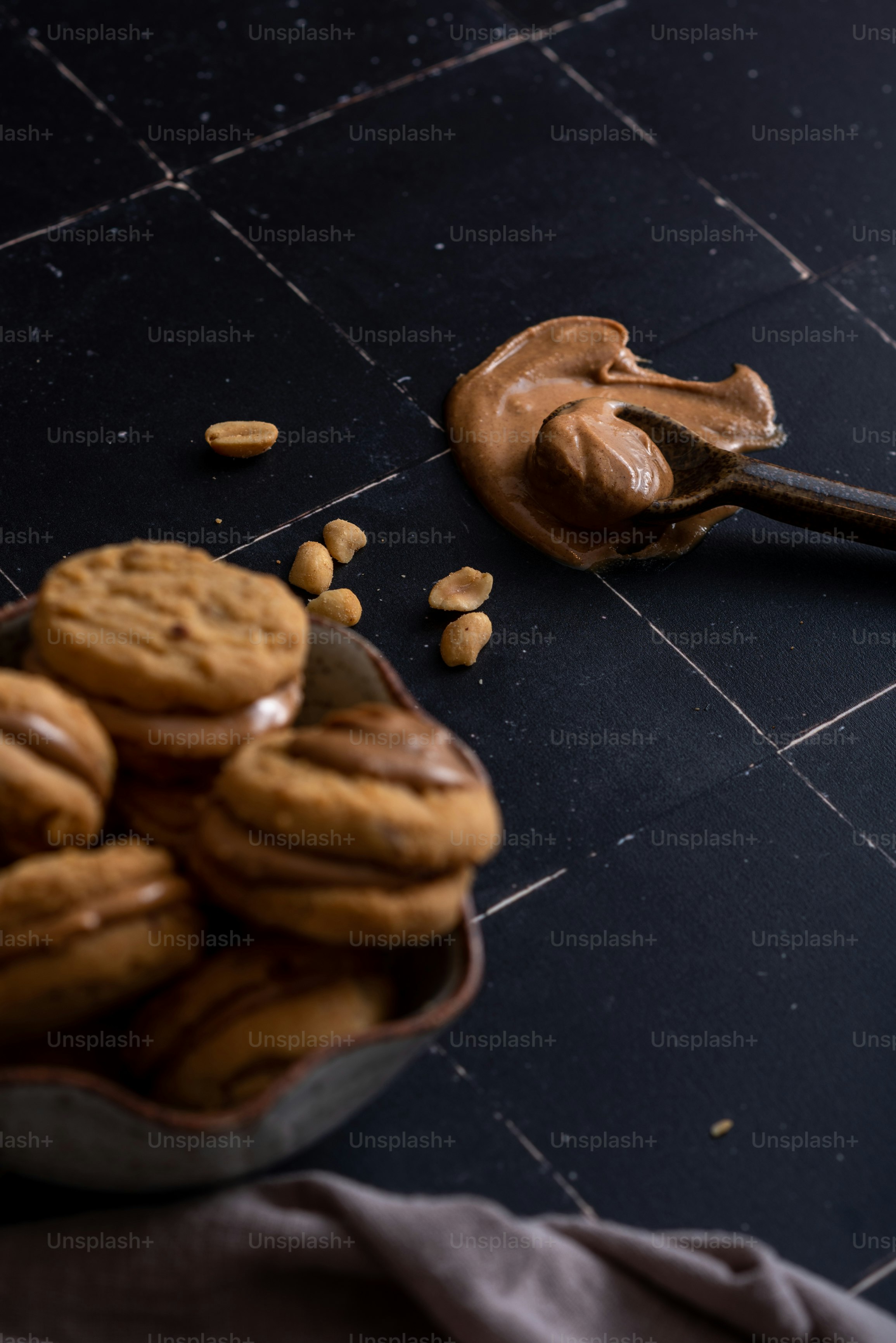 a bowl of cookies and a spoon of peanut butter