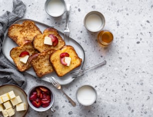 a white plate topped with french toast and fruit