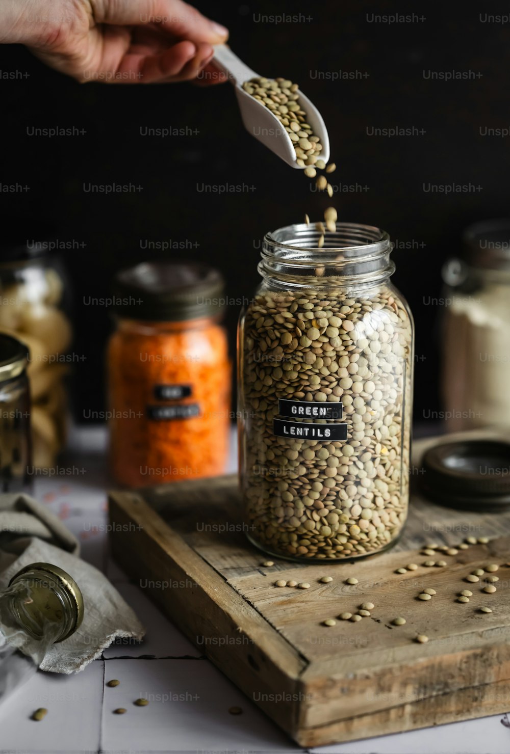 a person scooping seeds out of a jar