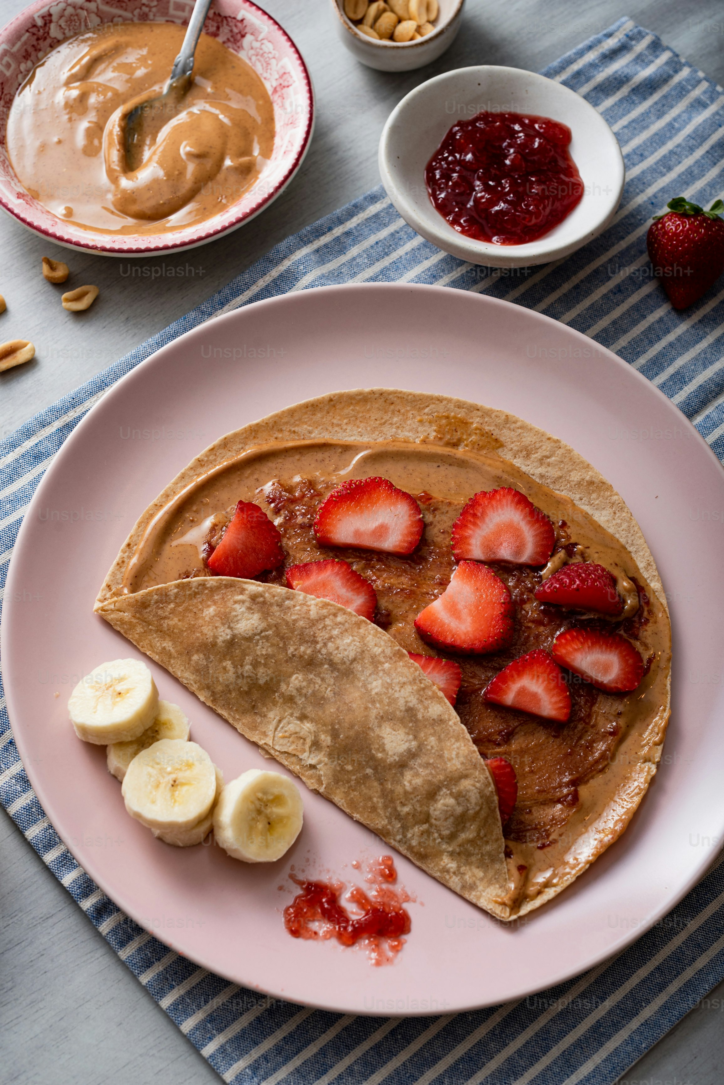 a plate of pancakes with bananas and strawberries