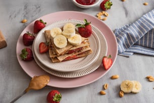 a plate topped with banana slices and strawberries
