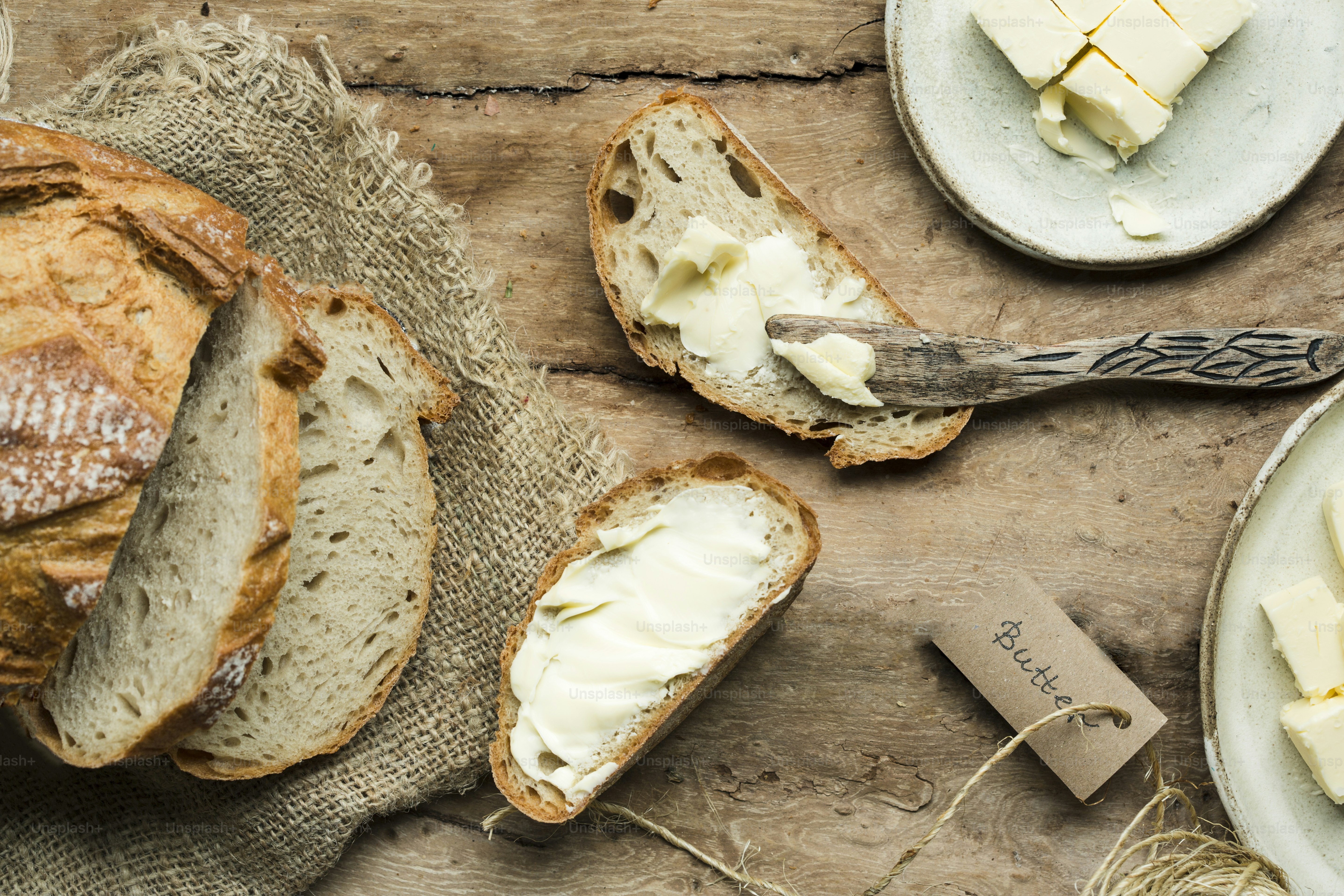 una mesa cubierta con pan y mantequilla encima de una mesa de madera