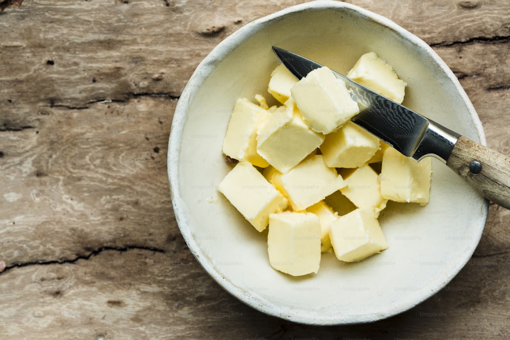 a bowl of butter cubes with a knife in it