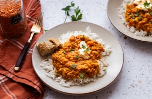 ein weißer Teller mit Reis und Curry