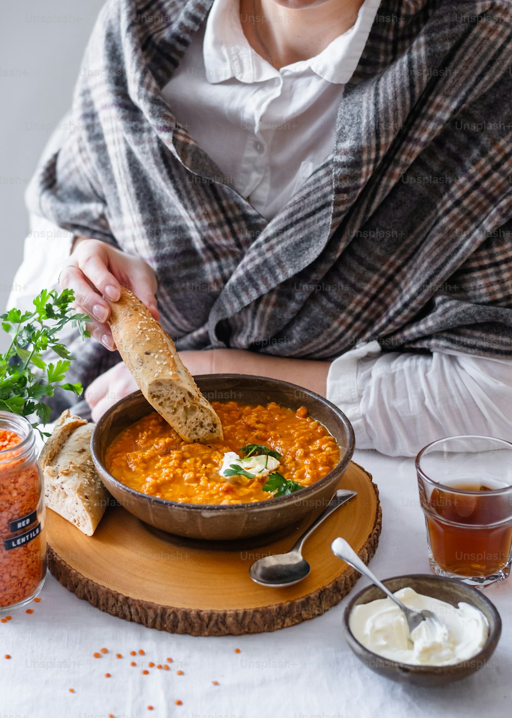 a person sitting at a table with a bowl of soup