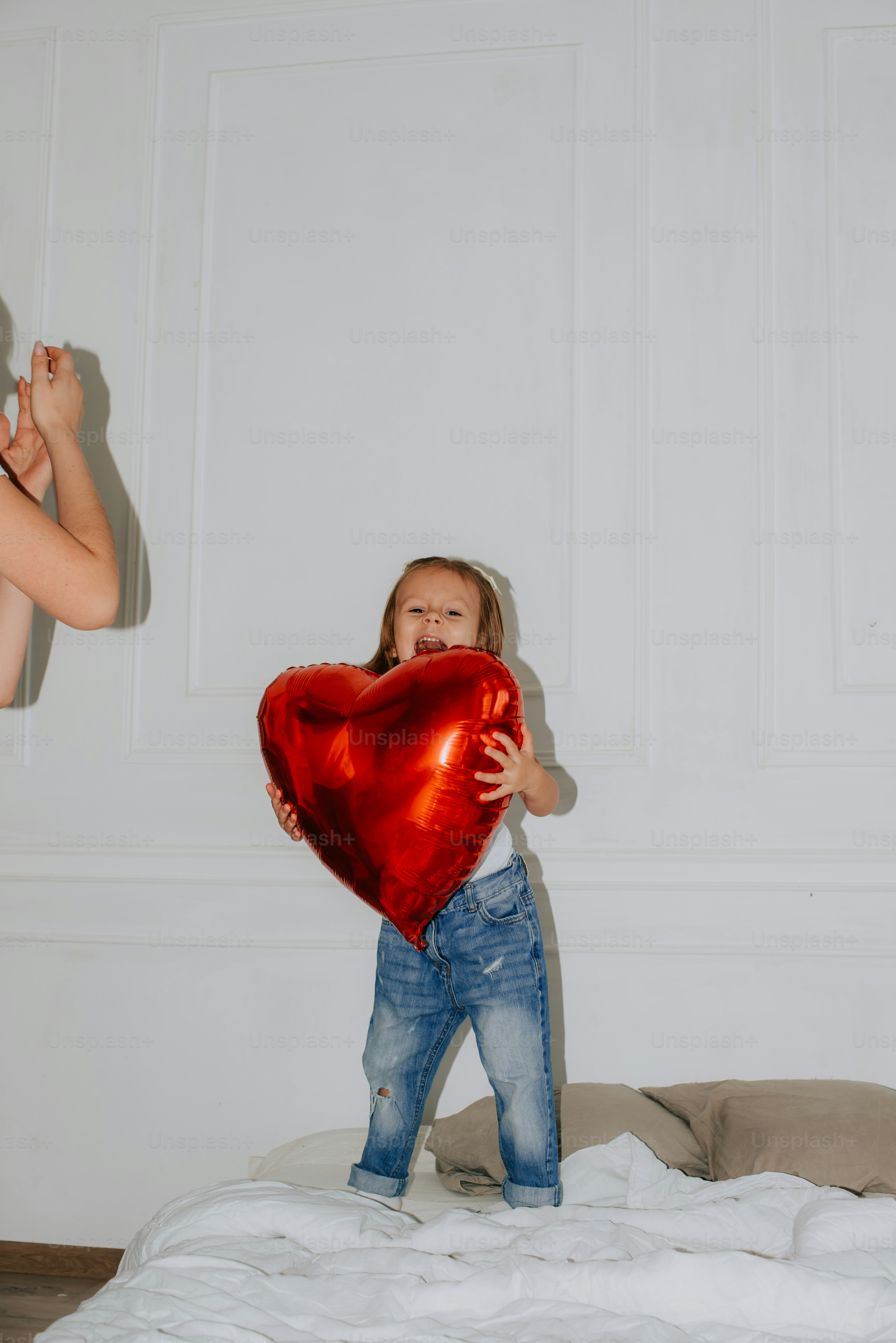 Seorang gadis kecil memegang balon berbentuk hati