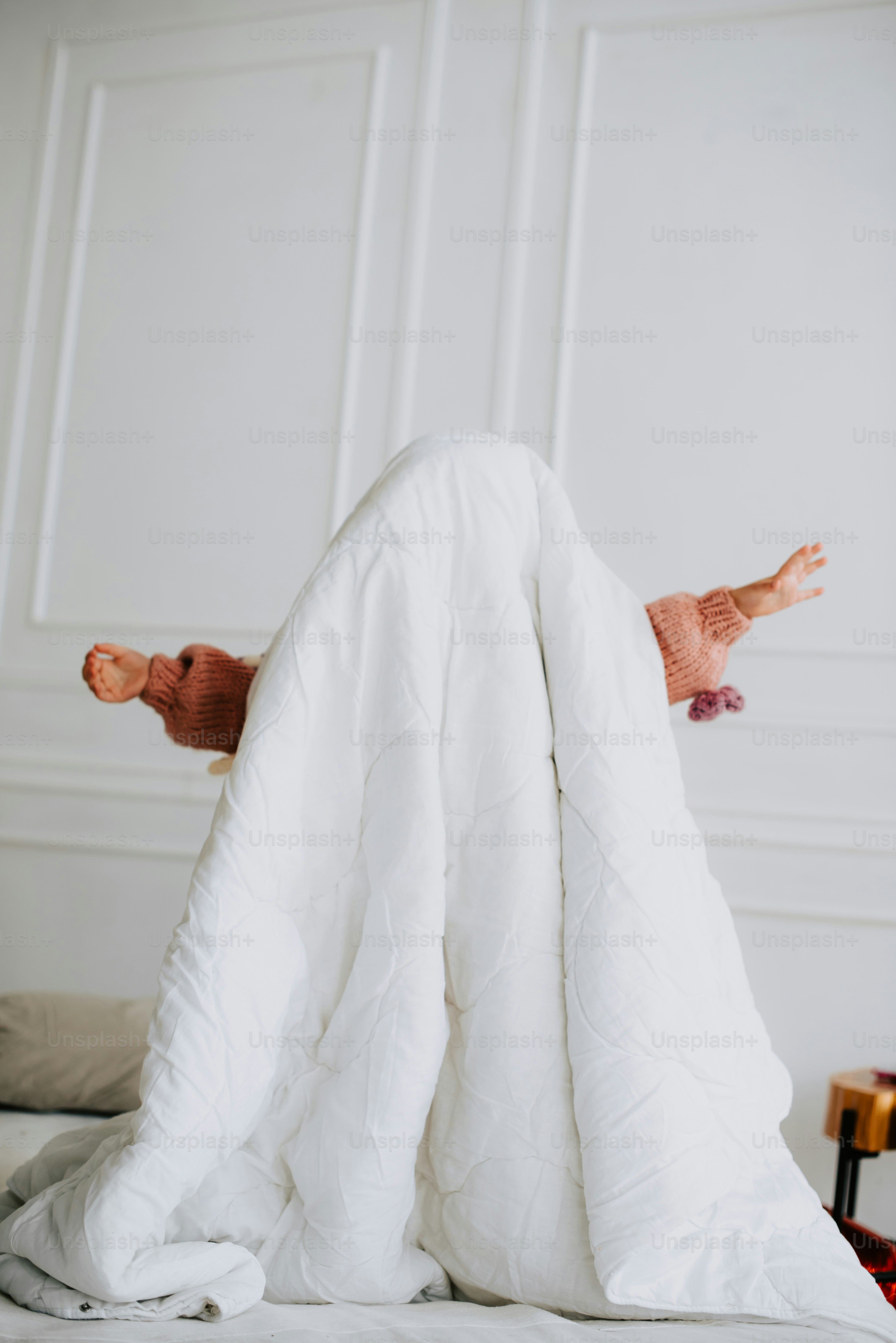 tempat tidur dengan selimut putih di atasnya