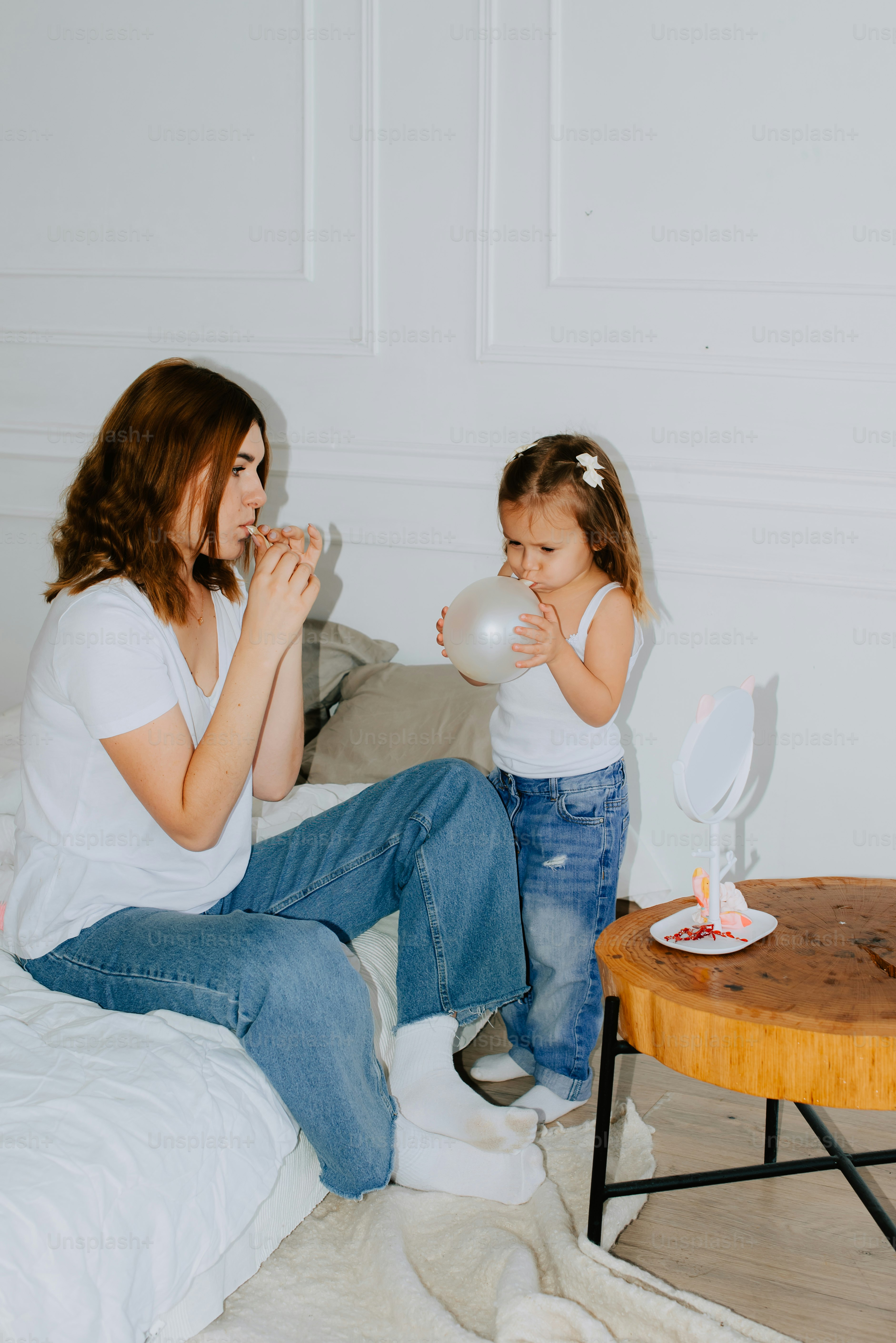 une femme assise sur un lit à côté d’une petite fille