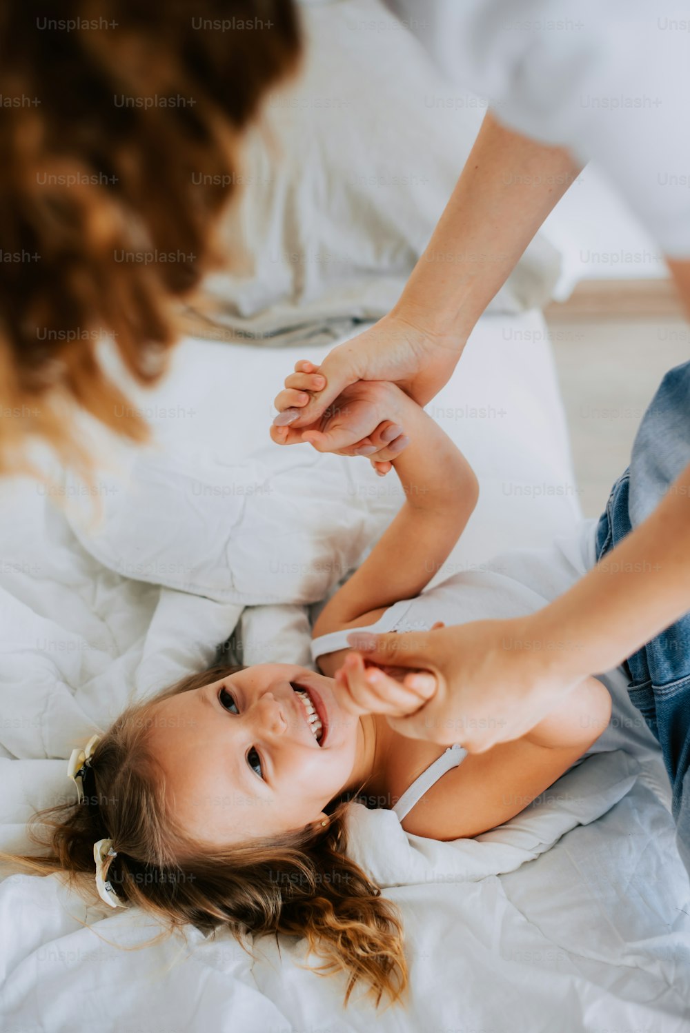 a little girl laying on top of a bed next to a woman