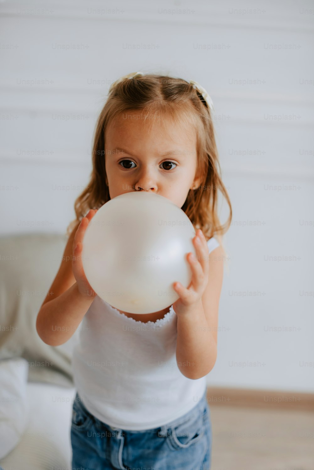 una bambina che tiene tra le mani un palloncino bianco