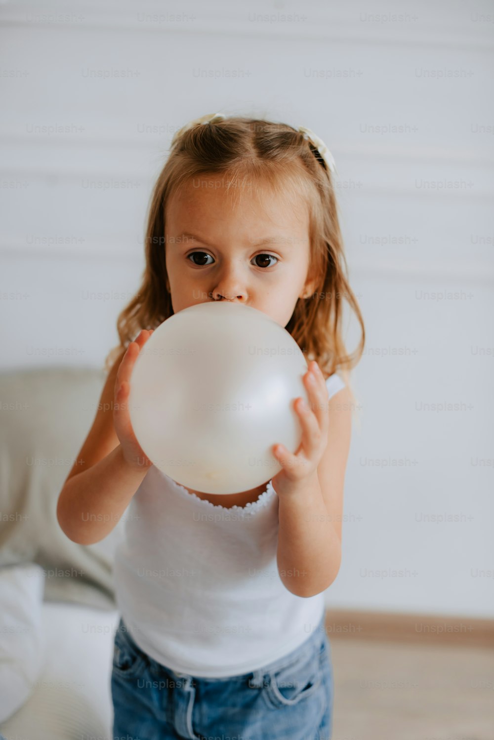 a little girl holding a white balloon in her hands
