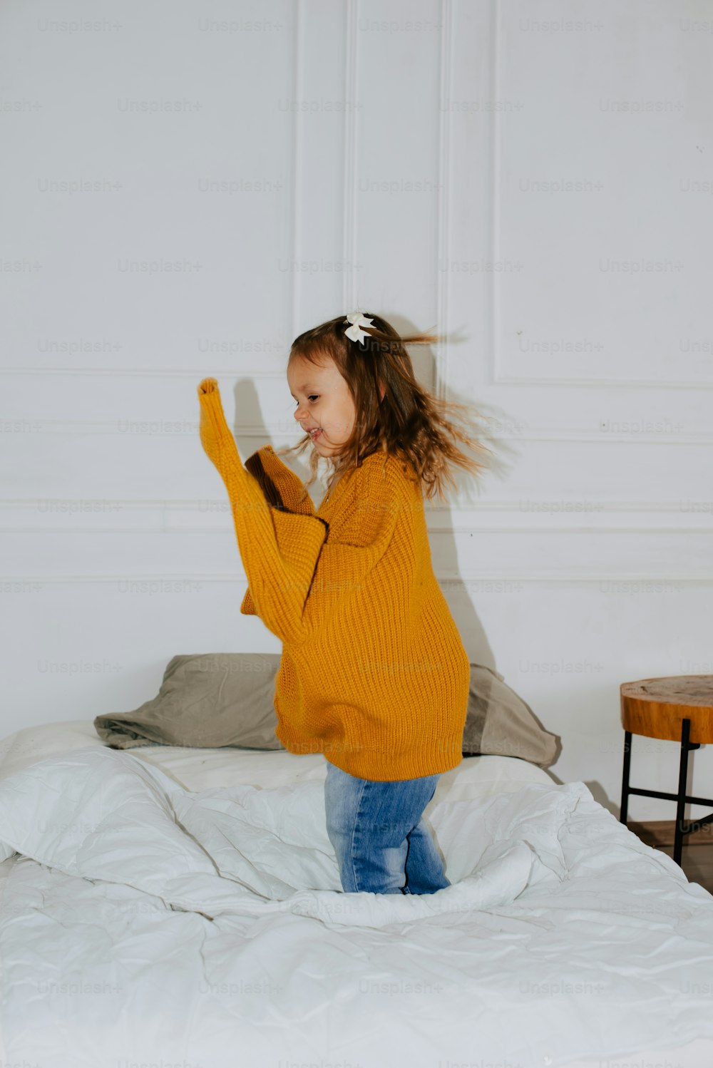 a little girl is jumping on a bed
