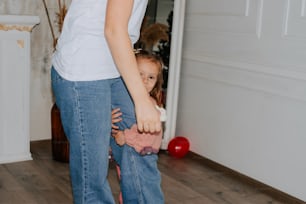 a woman holding a little girl's hand while standing in a room