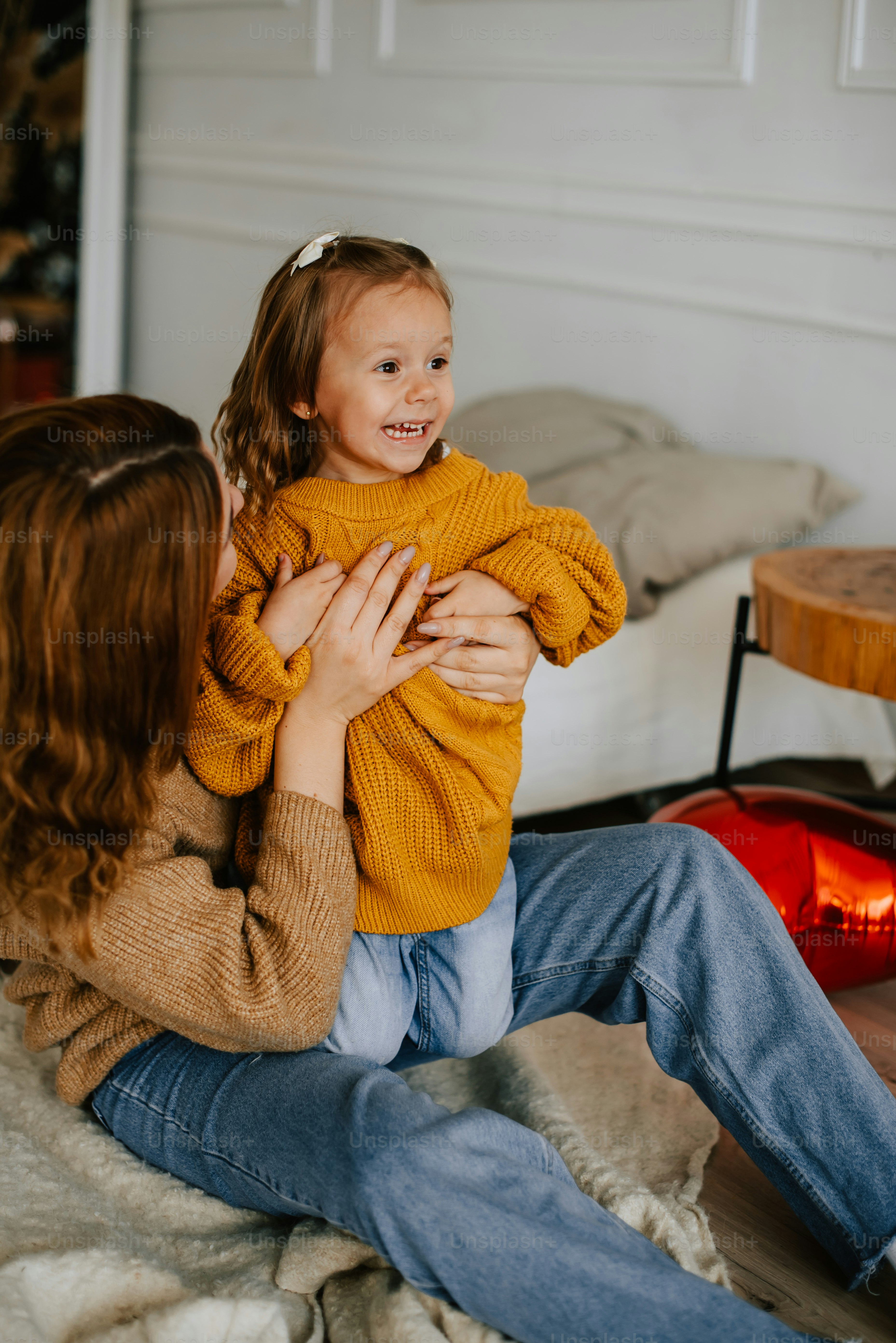 a woman sitting on a bed holding a little girl