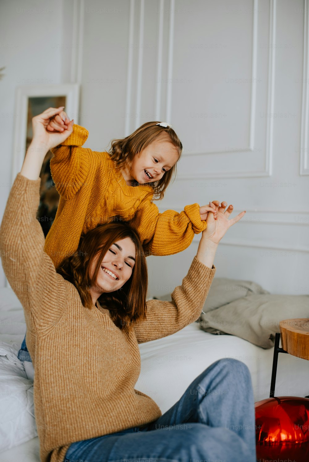 a mother and daughter playing on a bed