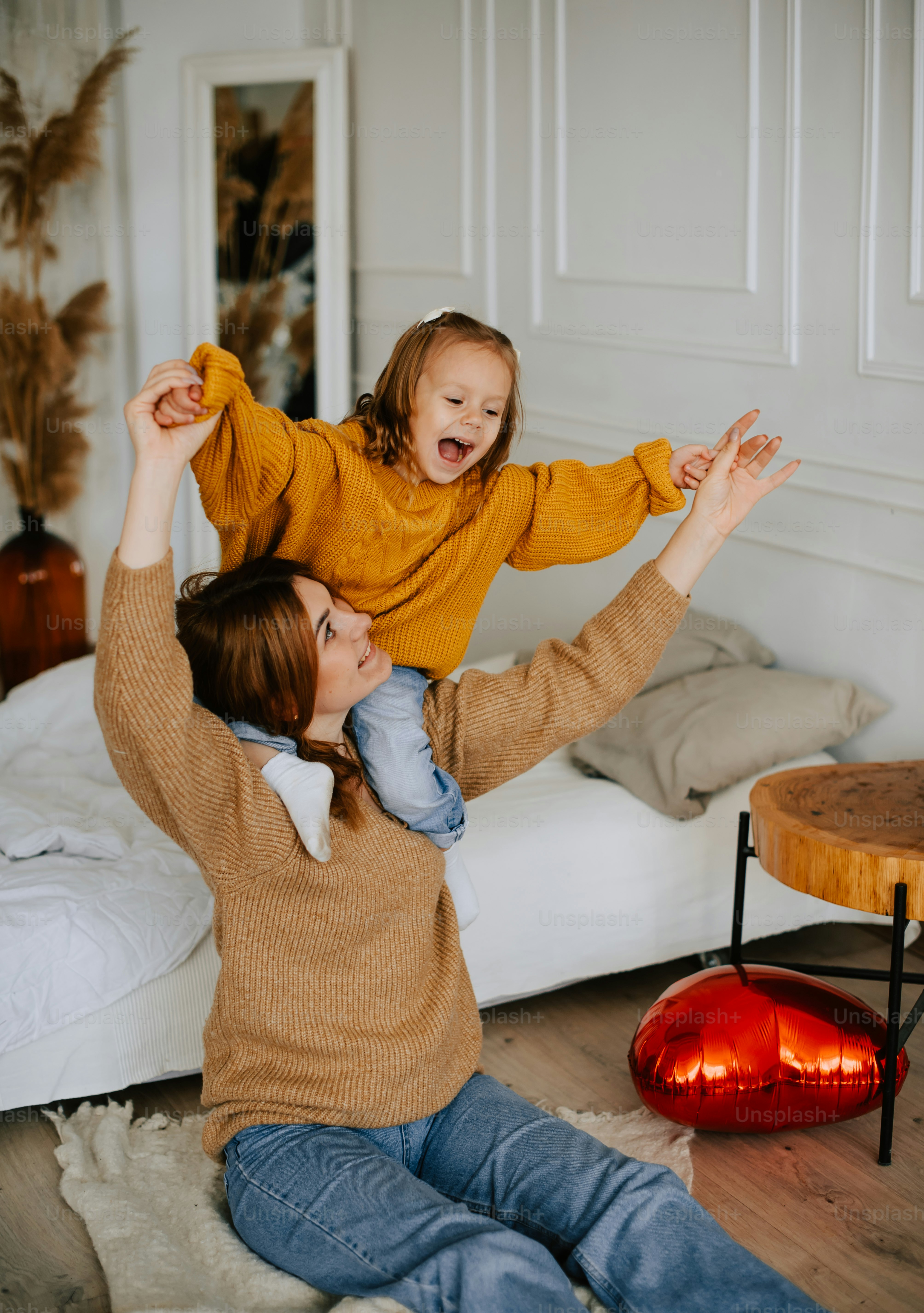 a woman and a child sitting on a bed