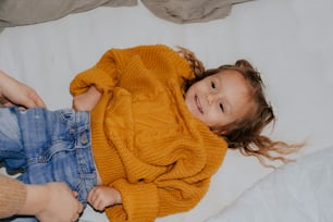 a little girl that is laying down on a bed