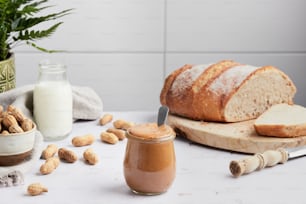 a loaf of bread sitting on top of a table next to a jar of almond