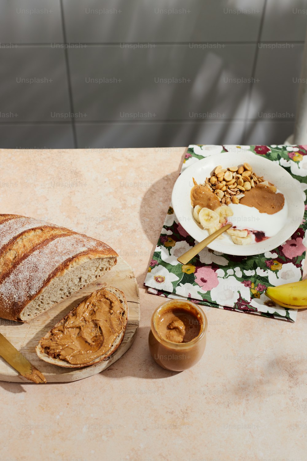 um pão sentado em cima de uma mesa ao lado de uma tigela de amendoim