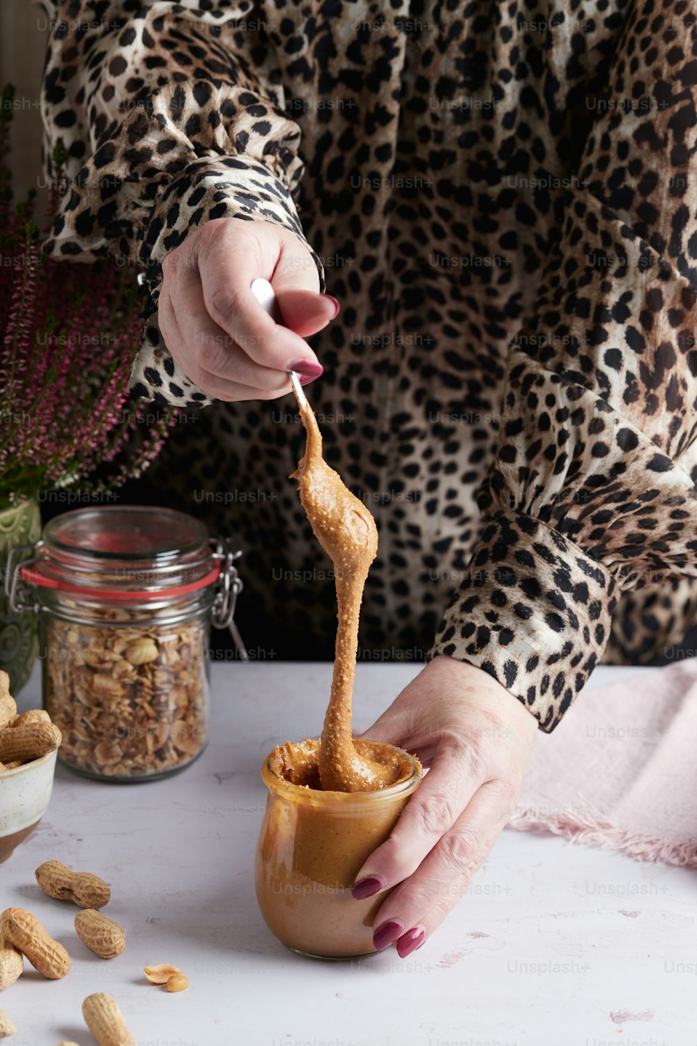 a woman holding a spoon full of peanut butter