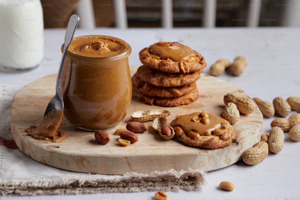 a jar of peanut butter next to a stack of cookies