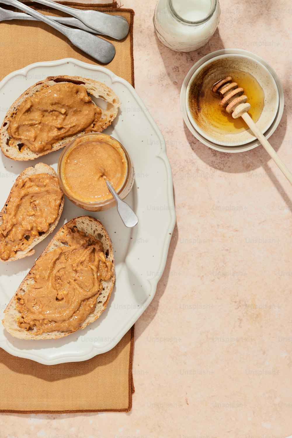 a plate of peanut butter and a cup of honey