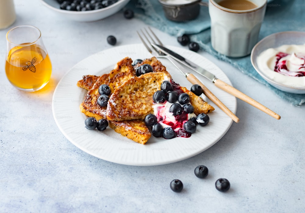 a white plate topped with french toast and blueberries