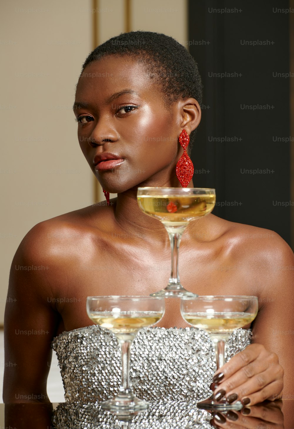 a woman in a silver dress holding a wine glass
