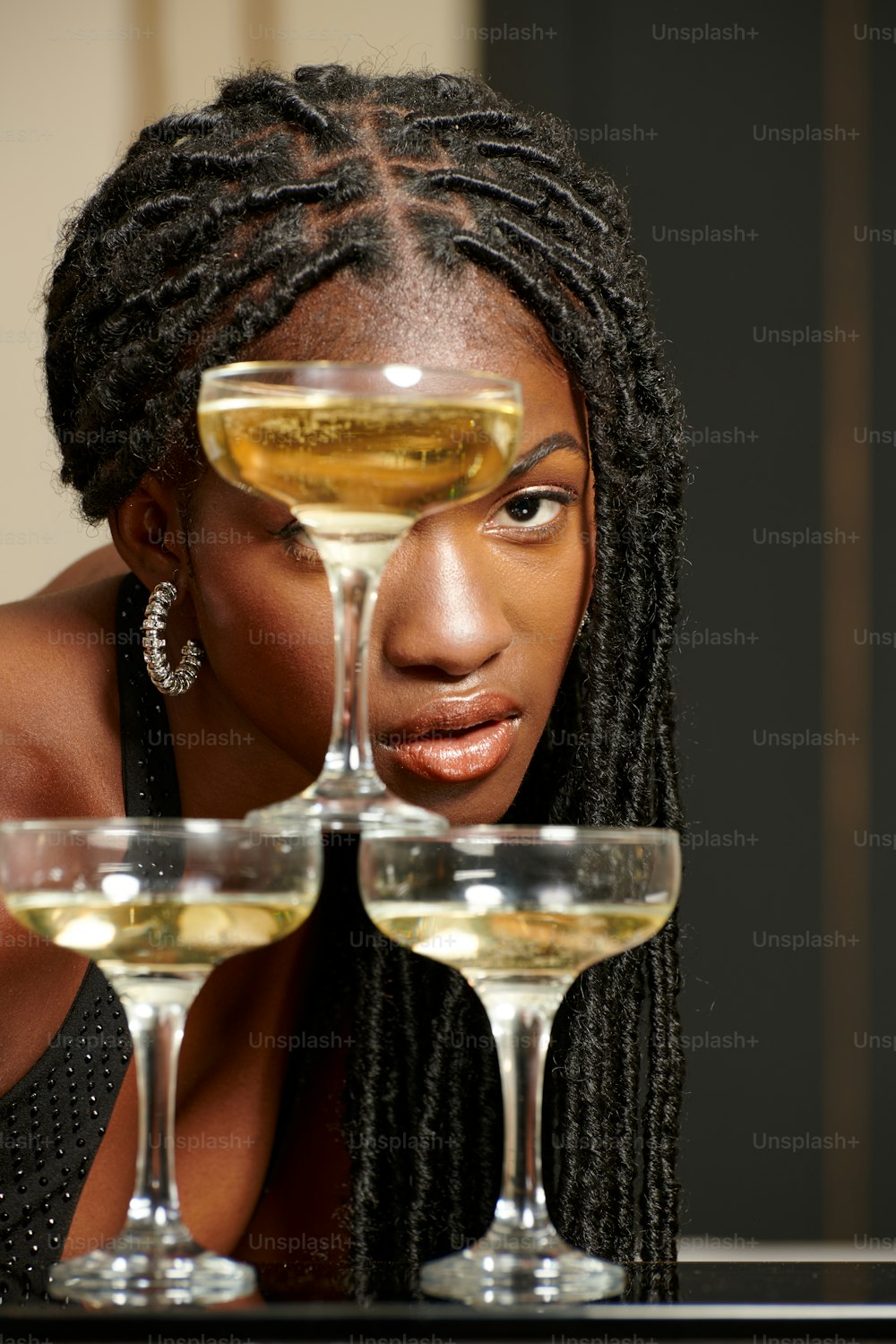 a woman sitting at a table with three glasses of wine