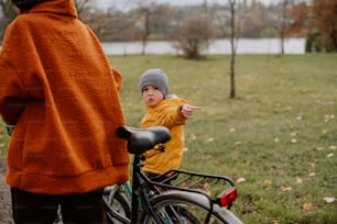 a little boy sitting on a bike pointing at something