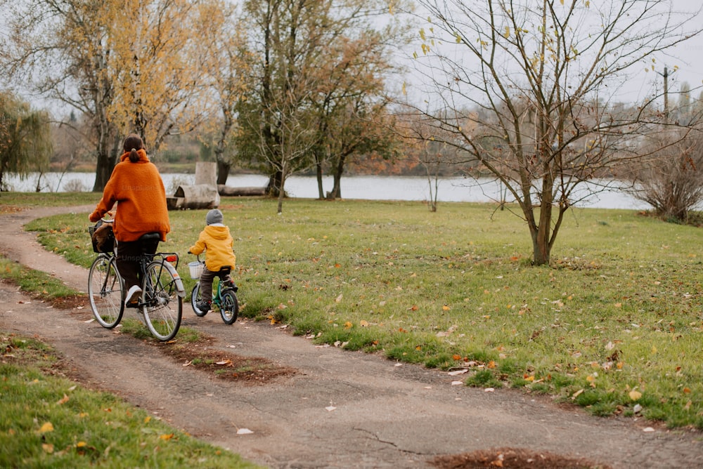 uma mulher andando de bicicleta com uma criança na parte de trás