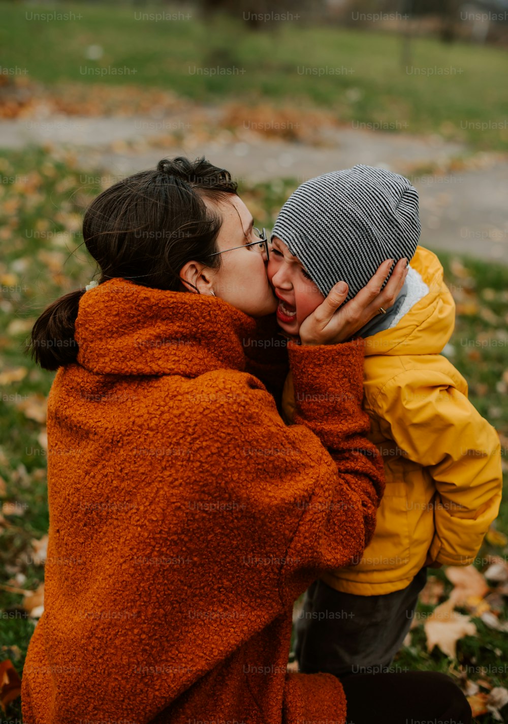 a woman kissing a child on the cheek