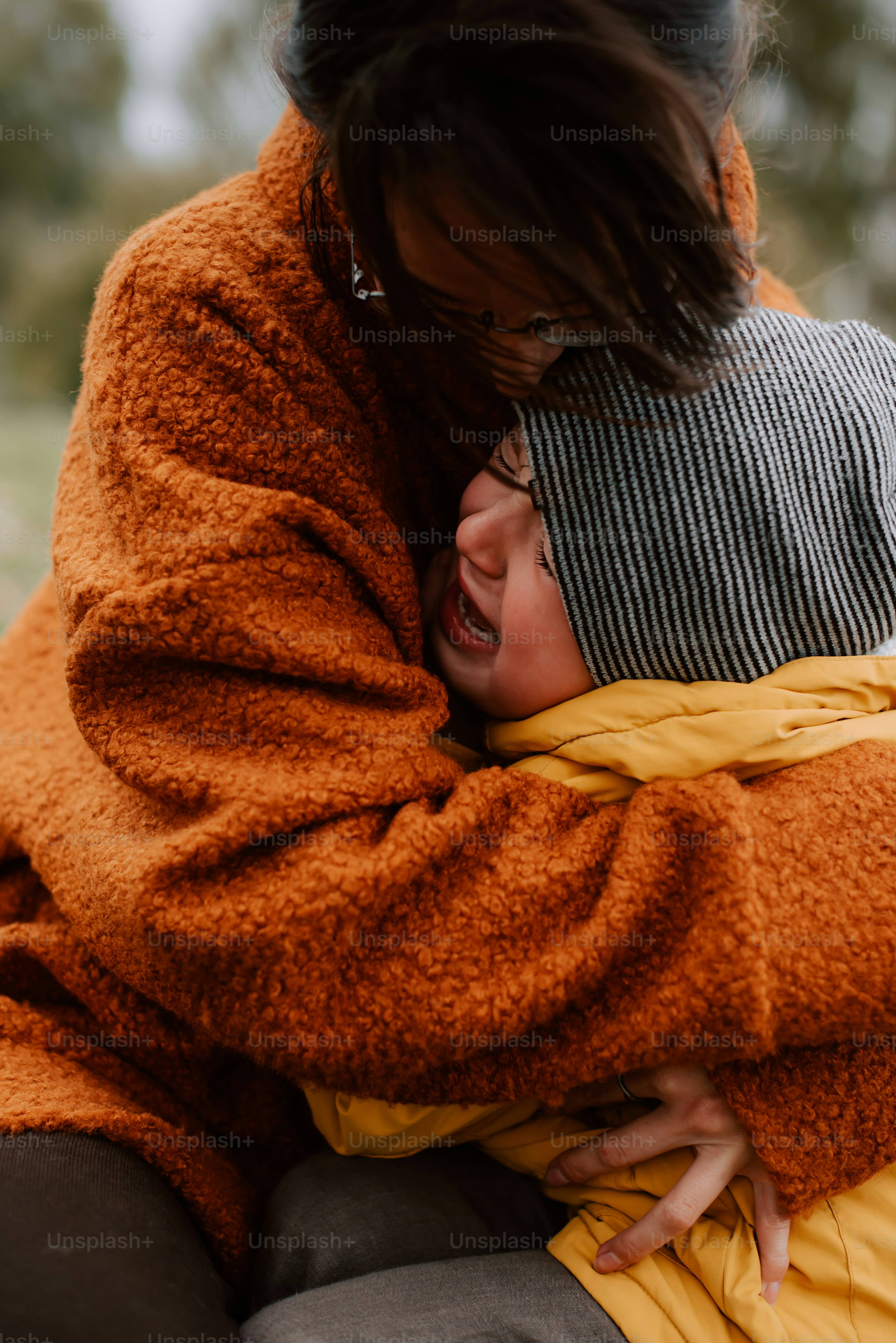 une femme tenant un bébé enveloppé dans une couverture