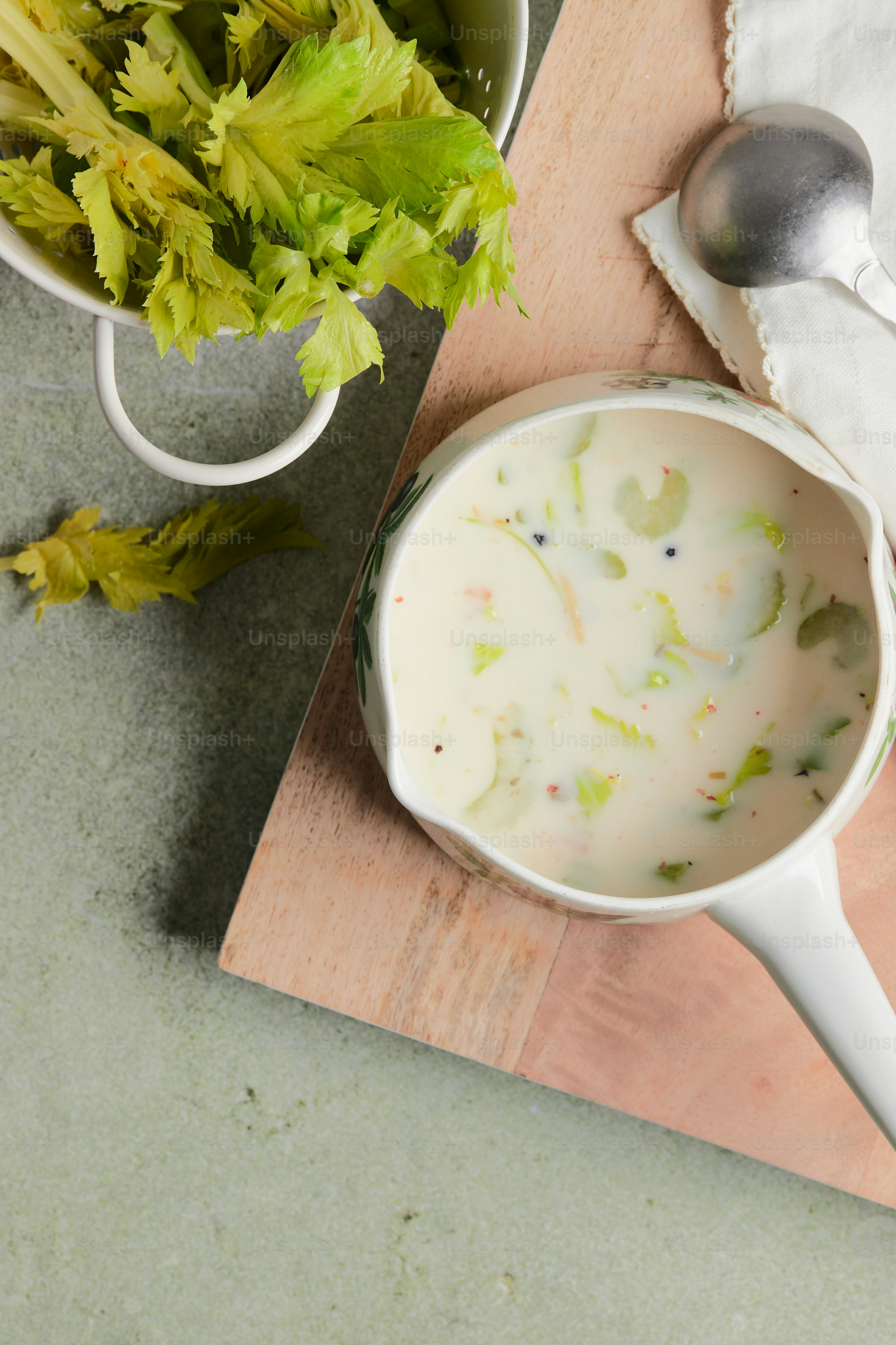 a bowl of soup next to a bowl of lettuce