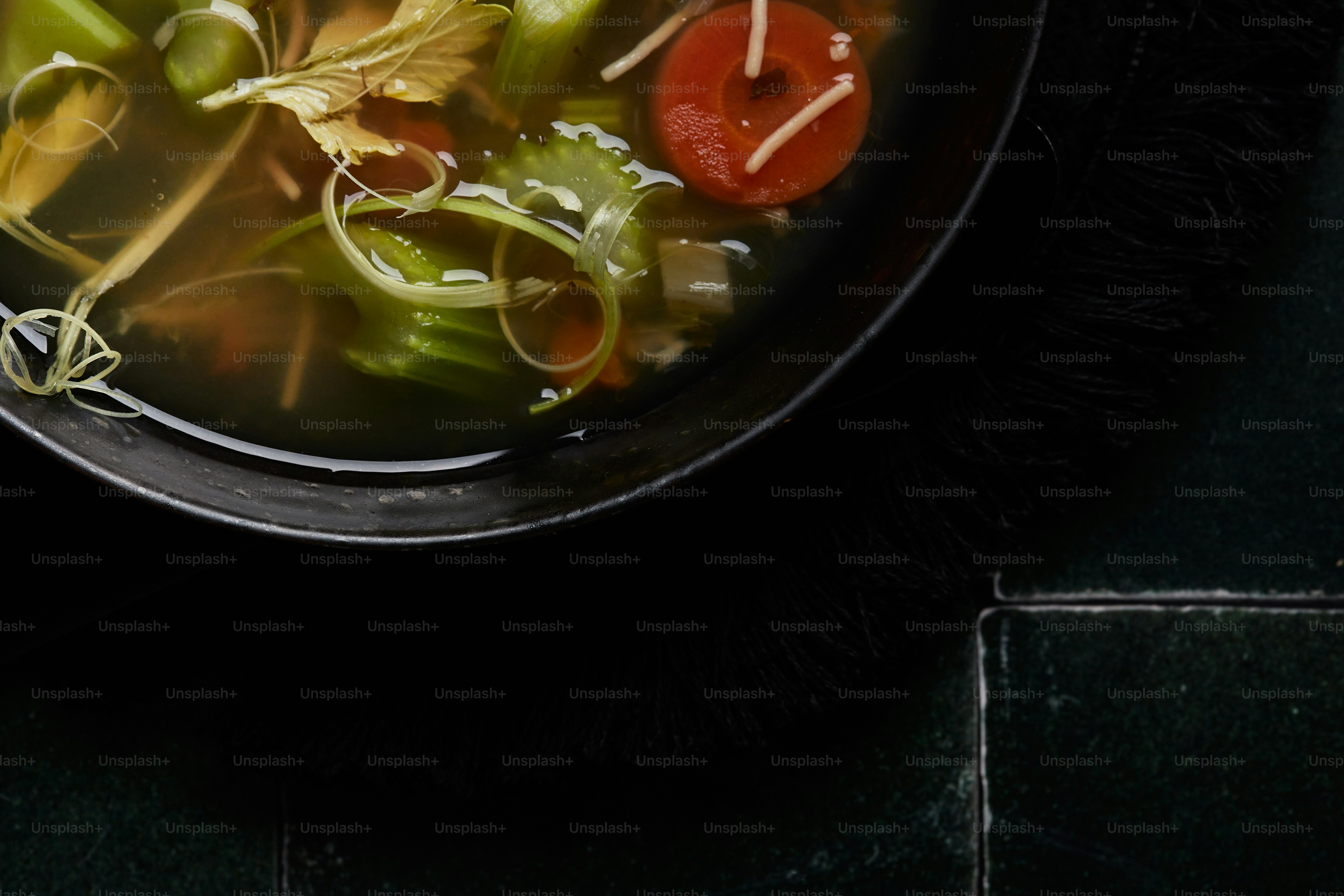 a bowl of soup with tomatoes and green beans