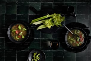 two bowls of soup with celery, carrots, and celery