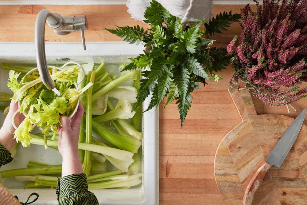a woman is cutting celery on a cutting board