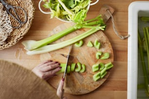a person cutting celery on a cutting board