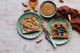 two plates with peanut butter and blueberries on them